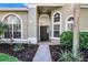 Charming front exterior with arched windows, a well-manicured landscape, and a welcoming entrance at 1367 Saddleridge Dr, Orlando, FL 32835