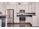 Bright kitchen features stainless steel appliances, white cabinetry, and dark granite countertops at 1367 Saddleridge Dr, Orlando, FL 32835