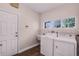 Bright laundry room with white washer and dryer, utility sink, and a window for natural light at 1367 Saddleridge Dr, Orlando, FL 32835