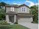 Charming two-story home with gray siding, stone accents, manicured lawn, and an attached two car garage at 1403 Dalkeith Cv, Sanford, FL 32771