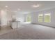 Bright, open-concept living room with plush carpeting, large windows, and a view to the backyard at 1409 Dalkeith Cv, Sanford, FL 32771