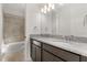 Bathroom featuring a granite countertop, dual sinks, dark wood cabinets, and tiled shower at 14165 Moniz Ave, Orlando, FL 32827