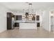 Spacious kitchen with stainless steel appliances, dark cabinets, granite counters, and stylish pendant lights at 14165 Moniz Ave, Orlando, FL 32827