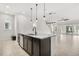 Kitchen island with seating, granite countertop, sink, and dishwasher with a view of the living area at 14165 Moniz Ave, Orlando, FL 32827