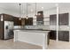 Modern kitchen features stainless steel appliances, dark cabinetry, and a granite-topped island with pendant lighting at 14165 Moniz Ave, Orlando, FL 32827