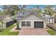 Charming home showcasing a brick driveway, attached garage, manicured lawn, and classic architectural details at 1517 E Esther St, Orlando, FL 32806