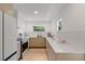 Bright kitchen features modern appliances, white countertops, and light hardwood floors at 1517 E Esther St, Orlando, FL 32806