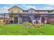 Backyard featuring lawn, professional landscaping, and screened-in porch area with colorful neighboring homes at 159 Captiva Dr, Davenport, FL 33896