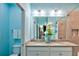 Well-lit bathroom features double sinks, granite countertops, and decorative floral arrangement at 159 Captiva Dr, Davenport, FL 33896