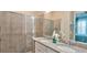 Bathroom featuring double sinks, granite countertops, and modern tiled glass shower at 159 Captiva Dr, Davenport, FL 33896