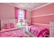 Pink bedroom featuring two beds, a chandelier, and bright natural light at 159 Captiva Dr, Davenport, FL 33896