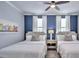 This bedroom has two beds with white linens and a blue accent wall for a bright, comfortable feel at 159 Captiva Dr, Davenport, FL 33896