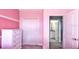 Bedroom in pink featuring a large dresser, closet, and adjoining bathroom access at 159 Captiva Dr, Davenport, FL 33896
