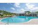A community pool featuring a zero-entry shallow water area with lounge chairs and umbrellas at 159 Captiva Dr, Davenport, FL 33896