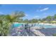 This is a community pool with lounge chairs and umbrellas on a sunny day at 159 Captiva Dr, Davenport, FL 33896