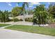 Landscaped home exterior featuring beautiful palms, a well-kept lawn, and stone pathway at 2440 Westwood Dr, Longwood, FL 32779