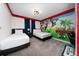 A spacious bedroom with two beds, gaming-themed mural, a modern light fixture, and plush carpeting at 2636 Reading Trl, Kissimmee, FL 34746