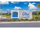 Entrance to The Cove East at Storey Lake features a stone sign and manicured landscaping under a bright, partly cloudy sky at 2636 Reading Trl, Kissimmee, FL 34746