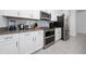 Modern kitchen with stainless steel appliances, white cabinetry, and tile backsplash at 2636 Reading Trl, Kissimmee, FL 34746