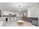 Open-concept living area featuring a modern kitchen with bar seating, a comfortable sofa, and stylish decor at 2636 Reading Trl, Kissimmee, FL 34746