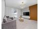 Cozy living room with a modern entertainment center, plush sofa, and natural light at 2636 Reading Trl, Kissimmee, FL 34746