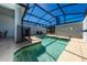 Private screened-in pool area with lounge chairs and a safety fence for children at 2636 Reading Trl, Kissimmee, FL 34746