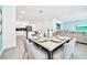 Well-lit dining area with a modern table setting adjacent to an open-concept kitchen and living space at 2661 Petition Ln, Kissimmee, FL 34746