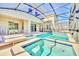 Beautiful in-ground pool and hot tub, complemented by ample seating and a screened enclosure at 2661 Petition Ln, Kissimmee, FL 34746