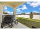 Covered back patio featuring rocking chairs, grill, and a view of the fenced yard at 2706 Rowan St, Tavares, FL 32778