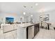 Open-concept kitchen featuring a large granite island, stainless steel appliances, and an adjacent dining and living area at 2706 Rowan St, Tavares, FL 32778