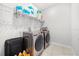 A well-organized laundry room features a washer, dryer, and shelving for ample storage solutions at 2706 Rowan St, Tavares, FL 32778