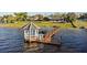 Charming waterfront scene featuring a gazebo and boat dock on the lake's edge near meticulously maintained lawns and neighboring properties at 2844 Marquesas Ct, Windermere, FL 34786