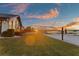 Spacious backyard featuring a beach volleyball court with serene lake views at sunset at 2844 Marquesas Ct, Windermere, FL 34786