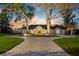 Elegant home boasts a circular driveway, arched windows and manicured lawn, with mature trees at 2844 Marquesas Ct, Windermere, FL 34786