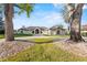View of the facade of the house featuring a circular driveway surrounded by mature trees at 2844 Marquesas Ct, Windermere, FL 34786
