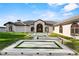 Elegant home with an arched entrance and a modern walkway design with artificial turf at 2844 Marquesas Ct, Windermere, FL 34786