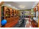 Spacious gym with hardwood floors, built-in shelving, and large windows leading to kitchen area at 2844 Marquesas Ct, Windermere, FL 34786