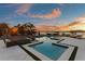 Modern pool with sleek design, spa, and lake views at sunset, perfect for relaxation at 2844 Marquesas Ct, Windermere, FL 34786