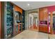 Unique wine cellar featuring custom glass and wood cabinets, stone archway, and travertine flooring for a sophisticated look at 2844 Marquesas Ct, Windermere, FL 34786