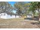 View of backyard with detached shed, home, fence, and shaded by mature trees at 3434 Se 12Th St, Ocala, FL 34471