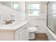 Bathroom featuring a tub with glass door, white tile, a toilet, and vanity with a mirror at 3434 Se 12Th St, Ocala, FL 34471