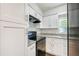 Bright kitchen featuring granite countertops, black appliances, and white cabinets offering storage at 3434 Se 12Th St, Ocala, FL 34471