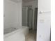 Bright bathroom with a tile floor, step-in shower, and relaxing soaking tub at 373 Caribbean Dr, Davenport, FL 33897