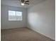 Neutral bedroom with beige carpeting, a ceiling fan, and a window overlooking the outside at 373 Caribbean Dr, Davenport, FL 33897
