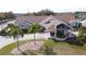 Exterior view of a beautiful community clubhouse with lush landscaping and palm trees at 373 Caribbean Dr, Davenport, FL 33897