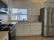 Bright kitchen featuring stainless steel appliances, white cabinets and light countertops at 373 Caribbean Dr, Davenport, FL 33897