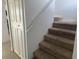 Carpeted stairway with white walls and wood handrail at 373 Caribbean Dr, Davenport, FL 33897