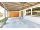 Covered carport area with a modern horizontal slat fence, providing shade and privacy alongside a neutral-colored home at 4429 Rossmore Dr, Orlando, FL 32810