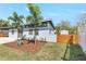 Charming home exterior with stylish fencing, xeriscape, and palm trees at 4429 Rossmore Dr, Orlando, FL 32810
