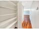View of the hallway featuring hardwood floors and an open closet with shelves at 4429 Rossmore Dr, Orlando, FL 32810
